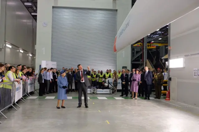 The Queen looking at a wind turbine blade.