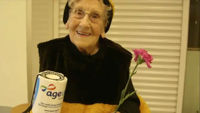 Jean Bishop dressed as a bee with an Age UK collection tin.