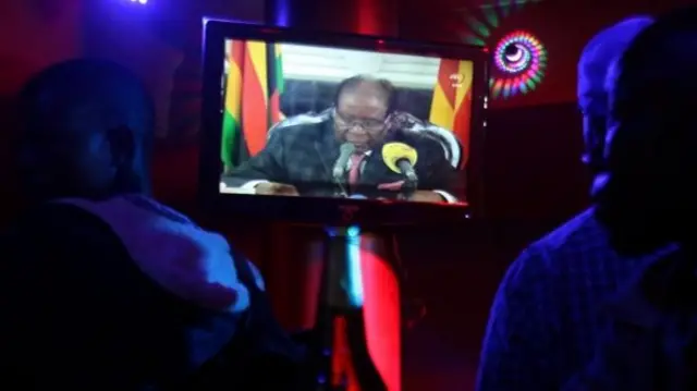 People watch President Mugabe's speech in a bar in Harare, Zimbabwe