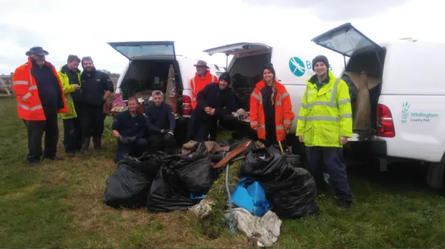 Members of the Broads Authority with bin bags of rubbish