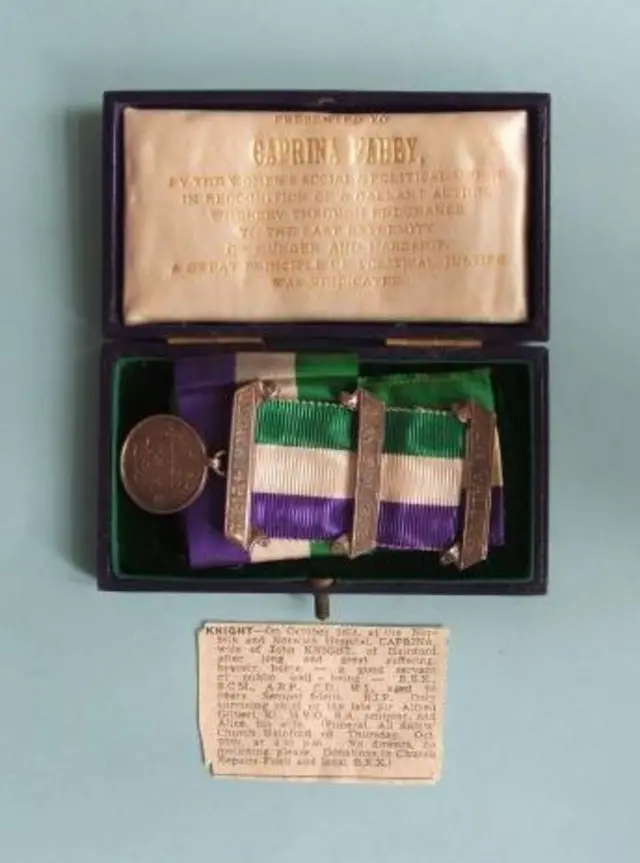 The medal, with green, cream and purple ribbon