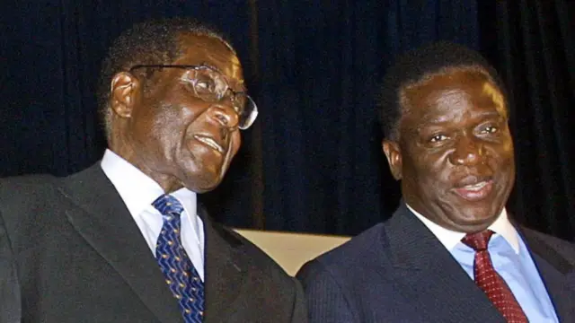 Zimbabwe's President Robert Mugabe (L) talks to Emmerson Mnangagwa, one of the two candidates running for the post of vice president 03 December 2004 at the Zanu-PF National People's Congress.