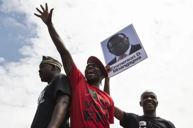 University of Zimbabwe"s students, holding a portrait of former vice president Emmerson Mnangagwa, take part in a demonstration on November 20, 2017 in Harare, to demand the withdrawal of Grace Mugabe"s doctorate and refused to sit their exams as pressure builds on Zimbabwe"s President Robert Mugabe to resign.