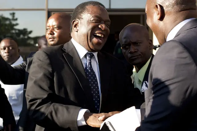 Emmerson Mnangagwa (C) is congratulated after being appointed as Zimbabwe's vice-president by President Robert Mugabe (unseen), on December 10, 2014 in Harare, Zimbabwe