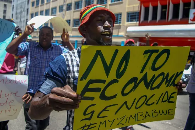 A protester holds a sign during a demonstration by opposition parties against the introduction of bond notes as a currency in Harare on November 30 201