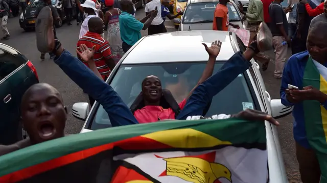 People celebrate in the streets of Harare, after the resignation of Zimbabwe"s president Robert Mugabe on November 21, 2017