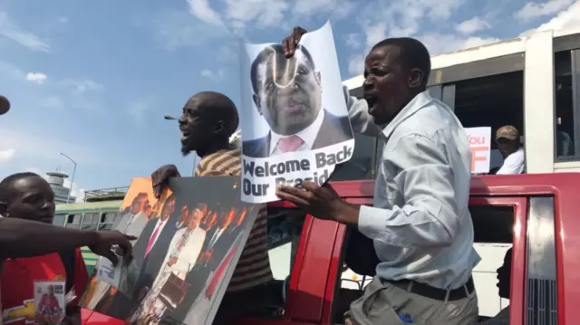 People holding Emmerson Mnangagwa posters