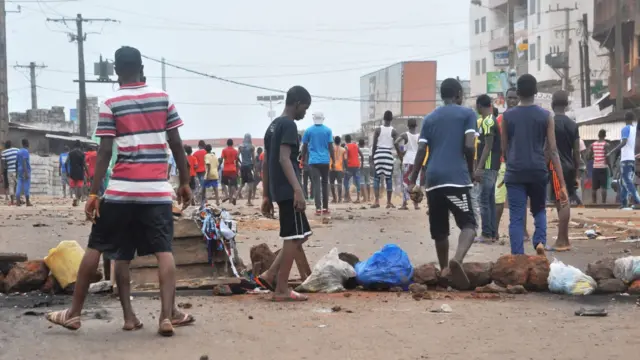 Protesters install barricades on the road during clashes with Guinean riot police officers in a district of Conakry on November 21, 2017