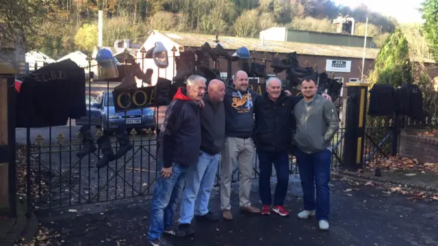 Aga foundry workers stand outside the gate