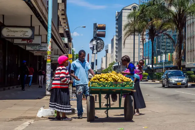 Residents buy fruits from a street vendor on November 20, 2017 in Harare.