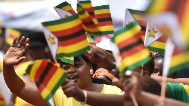 People react as Zimbabwean new President Emmerson Mnangagwa is officially sworn-in during a ceremony in Harare on November 24, 2017.