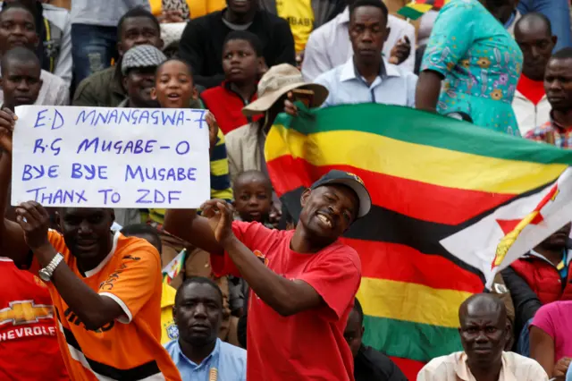 Crowd in stadium holding up a sign