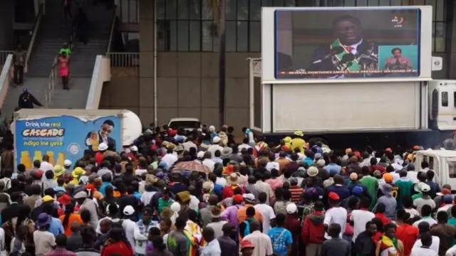 People watching the ceremony on a screen outside the stadium