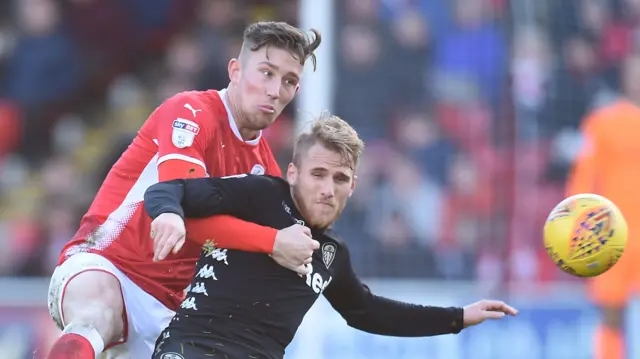 Angus MacDonald of Barnsley and Samuel Saiz of Leeds United.