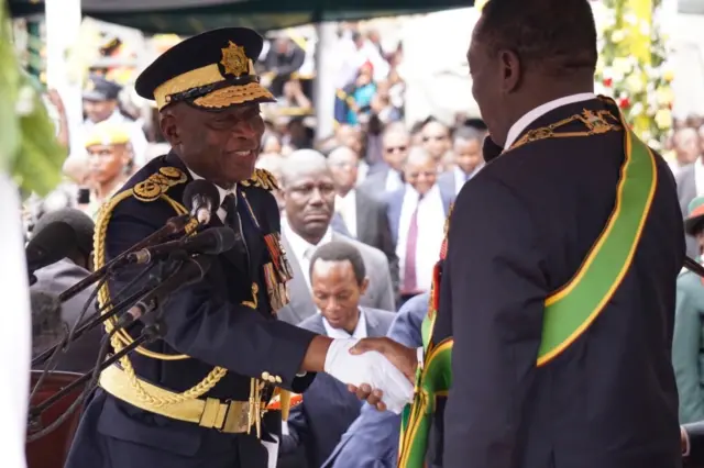 Commisioner General for police Augustine Chihuri (L) shakes hands with Zimbabwe"s new President Emmerson Mnangagwa during his inauguration on November 24, 2017.