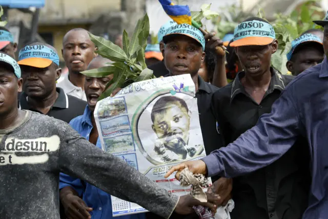 Ogoni indigenes carrying a poster of Ken Saro-Wiwa march on the Port Harcourt highway 10 November 2005. Hundreds of Ogoni indigenes marched on a Port Harcourt highway in remembrance of late civil rights activist and environmentalist Ken Saro-Wiwa that was executed on November 10, 1995 by military dictator General Sani Abacha for spear-heading the struggle against environmental degradation of Ogoniland by Shell oil.