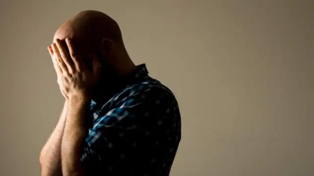 Man holding head in his hands