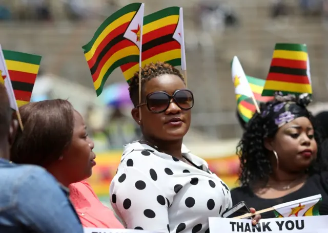 Zimbabweans look on ahead of the swearing in ceremony in Harare, Zimbabwe, November 24, 2017.