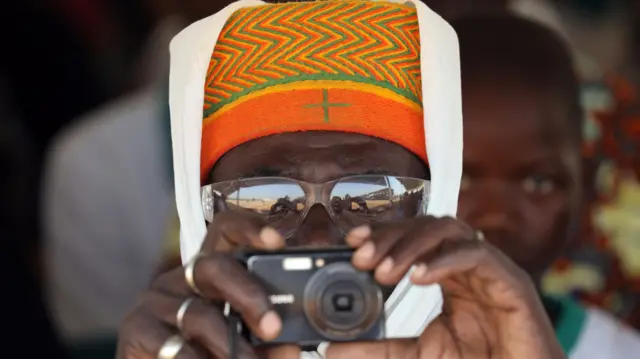 A man takes a picture during the inauguration ceremony of the solar energy power plant in Zaktubi, Burkina Faso - 29 November 2017