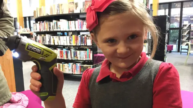 Young girl with a hand drill