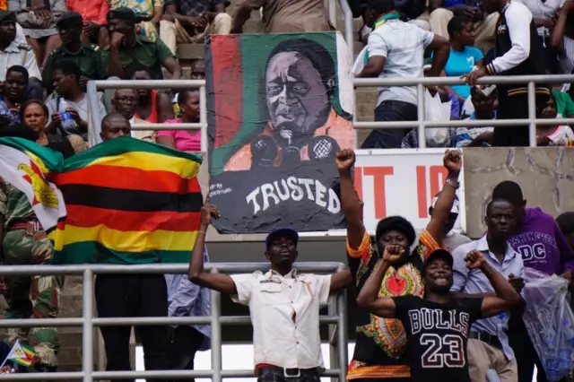 Supporters hold a portrait of Zimbabwes new President Emmerson Mnangagwa during his inauguration on November 24, 2017 in Harare.