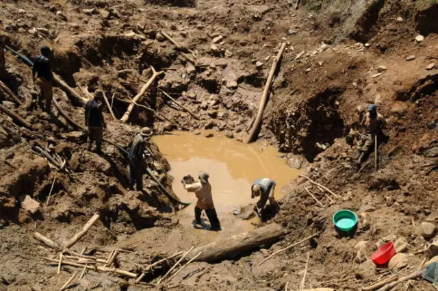 A team of miners shift mud in an open pit gold mine on May 15, 2008 in Mongwalu, north eastern Democratic Republic of Cong