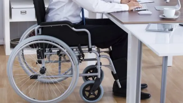 A wheelchair user in an office