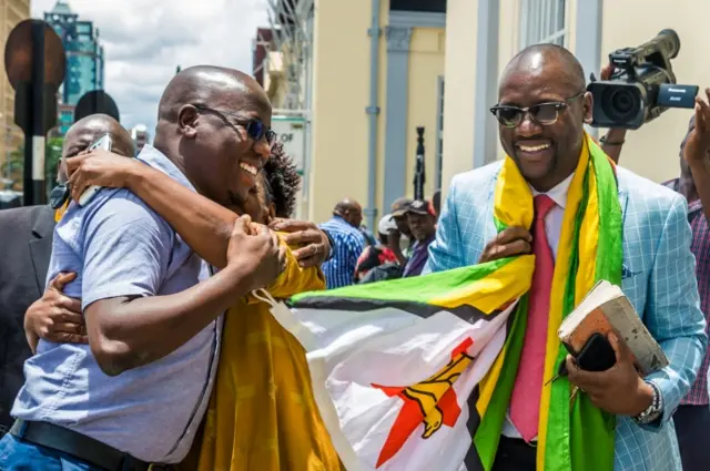 Zimbabwe cleric Pastor Evan Mawarire celebrates with his supporters on November 29, 2017 outside the High Court in Harare