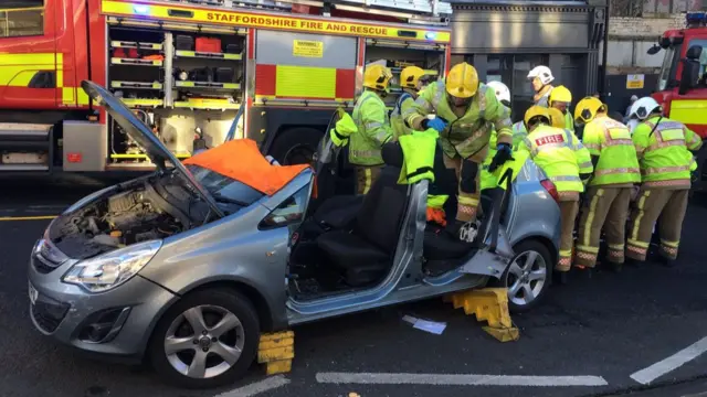 Fire crews around car after roof cut off