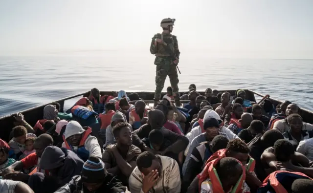 A Libyan coast guardsman stands on a boat during the rescue of 147 illegal immigrants attempting to reach Europe off the coastal town of Zawiya in June 2017