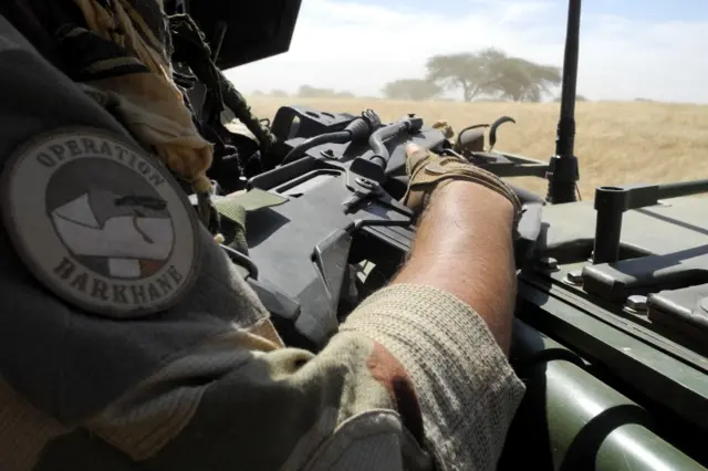 A soldier of France's Barkhane mission holds a weapon as he patrols in central Mali