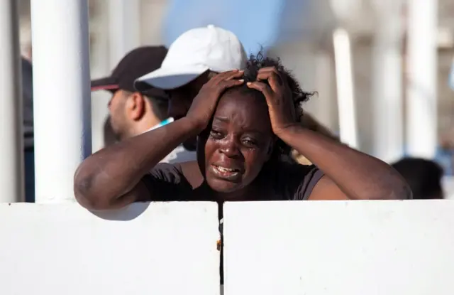 A migrant cries on the Italian Coast Guard ship Diciotti as it arrives in the harbor of Reggio Calabria, Italy