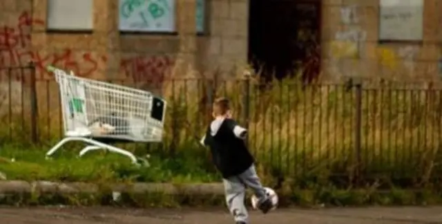 Child playing football in street