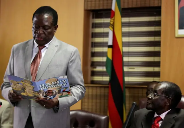 Zimbabwe's President Robert Mugabe looks on as his deputy Emmerson Mnangagwa reads a card during Mugabe"s 93rd birthday celebrations in Harare, Zimbabwe, February 21, 2017.