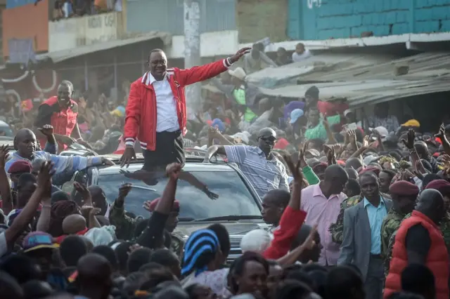 President Uhuru Kenyatta (front C) as he gestures and speak from a car roof with Deputy-President William Ruto (rear L), during a political rally in Nairobi, on October 23, 2017