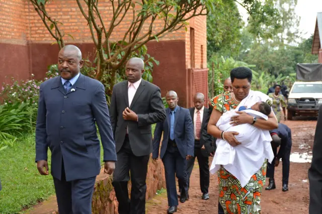 Burundi's First Lady Denise Nkurunziza walks to church with the baby in her arms