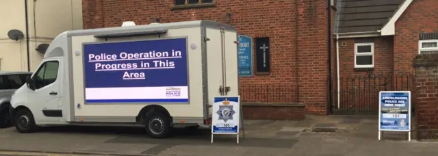 Police van with a screen on its side saying "police operation in progress"