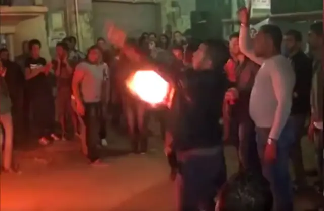 Wedding celebrants in Egypt shown dancing with one firing a shot from a handgun