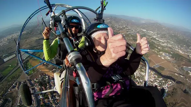 Connie Smith holding two thumbs up while in the air