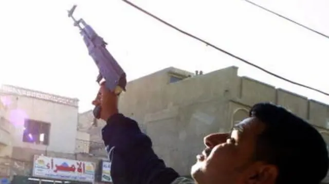 A man is seen firing a handgun into the air