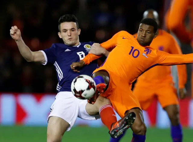 John McGinn challenges Netherlands' Georginio Wijnaldum for the ball