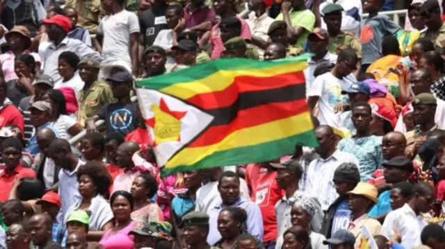 Citizens celebrate with the national flag during the swearing in ceremony of Emmerson Mnangagwa as Zimbabwe's new president