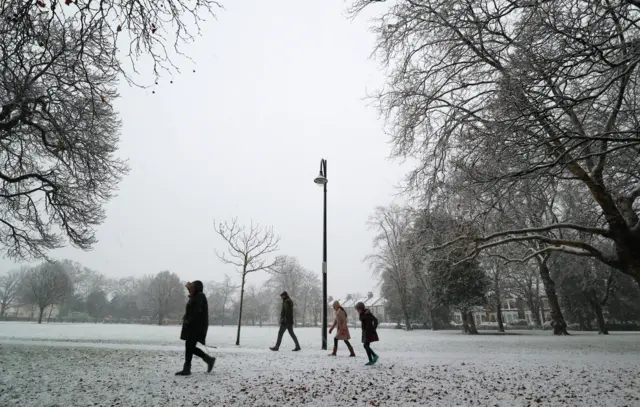 people wrapped up warm in a thin covering of snow