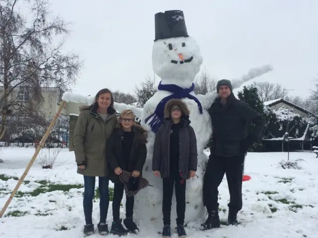 The Mitchell family with their large snowman in Chelmsford