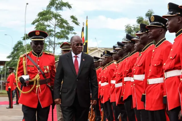 Tanzanian President John Magufuli reviews a military honour guard before attending the launching ceremony of a one-stop border post to speed up slow customs processing at the border and the laying of the cross-border marker for the construction of the East Africa Crude Oil Pipeline (EACOP) in Mutukula, Uganda, on November 9, 2017.