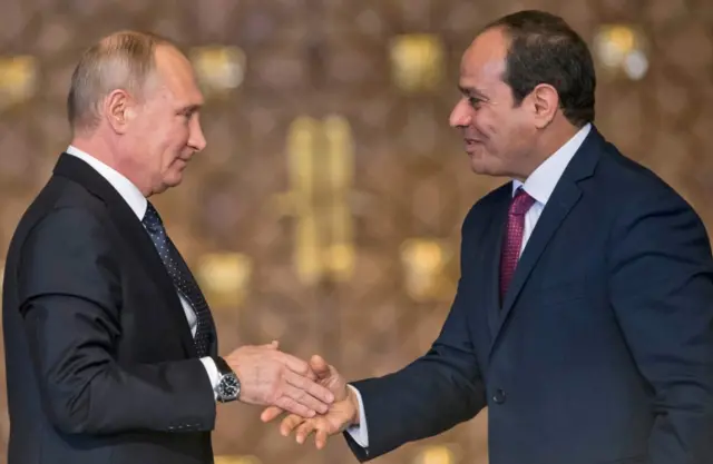 Russian President Vladimir Putin (L) shakes hands with Egyptian counterpart Abdel Fattah al-Sisi after giving a press conference following their talks at the presidential palace in the capital Cairo on December 11, 2017