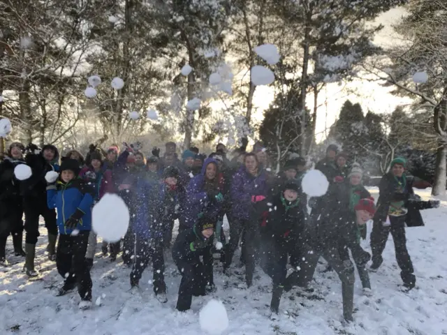 Group throwing snowballs at the photographer