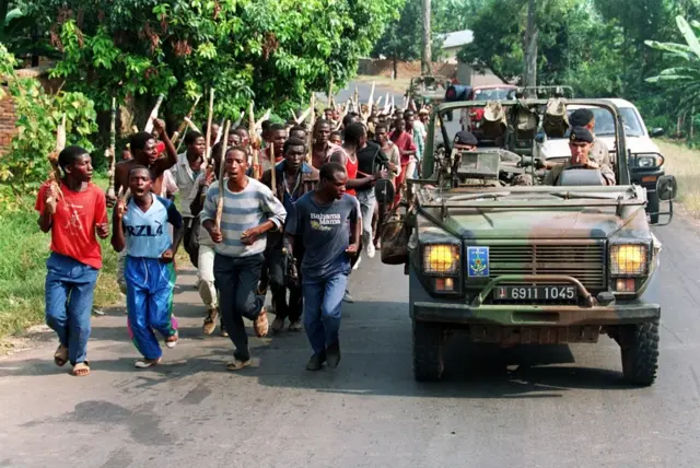 ws French soldiers on patrol passing ethnic Hutu troops from the Rwandan government forces, near Gisenyie