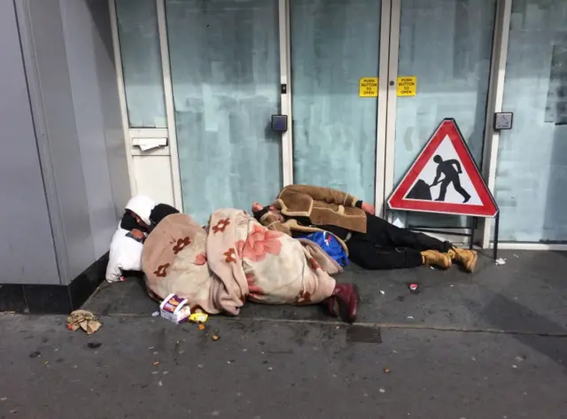 rough sleepers at a doorway