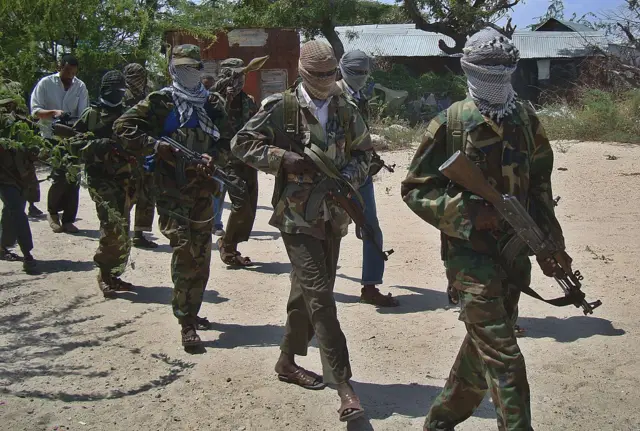 Al-Qaeda linked al-shabab recruits walk down a street on March 5, 2012 in the Deniile district of Somalian capital, Mogadishu, following their graduation